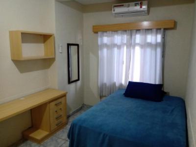 una camera con un letto blu e una finestra di A Casa Laranja a Florianópolis