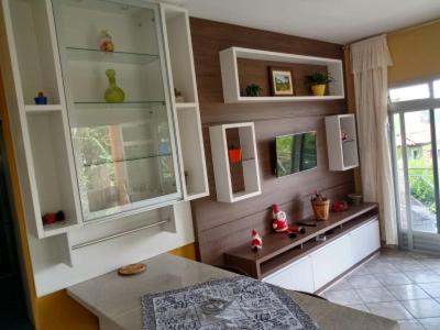 a kitchen with white cabinets and a table and a window at A Casa Laranja in Florianópolis