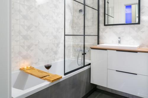 La salle de bains est pourvue d'une douche en verre, d'une baignoire et d'un plateau avec du vin. dans l'établissement Apartament Sophie - Samozameldowanie - Self check-in, à Rzeszów