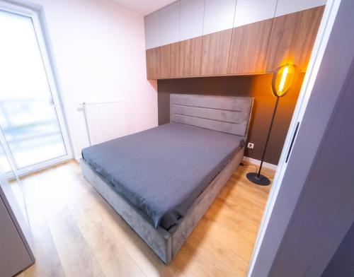 - une chambre avec un lit dans un dortoir doté d'une lampe dans l'établissement Apartament Sophie - Samozameldowanie - Self check-in, à Rzeszów