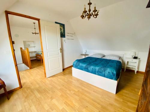 - une chambre avec un lit et un miroir dans l'établissement Jolie maison bourg de Penvenan, à Penvénan