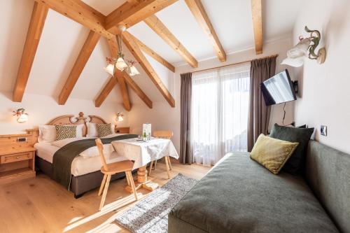 a bedroom with a bed and a table and a couch at B&B Grüne Laterne - Lanterna Verde in Sesto