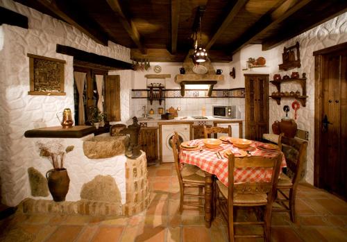une cuisine avec une table et des chaises dans une pièce dans l'établissement Casa Rural Margarita II, à Montánchez