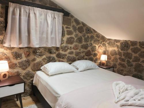 a bedroom with a bed with two pillows and a window at Erofili in Kato Trikala Korinthias