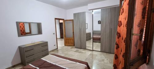 une chambre avec un lit, une commode et un miroir dans l'établissement Dal Falegname, à Roccalumera