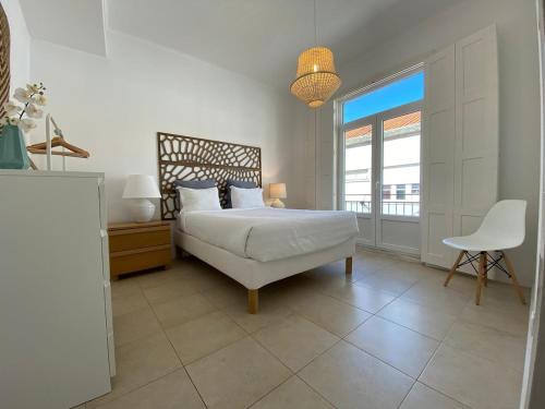 a bedroom with a bed and a desk and a chair at Setúbal Downtown Apartments in Setúbal