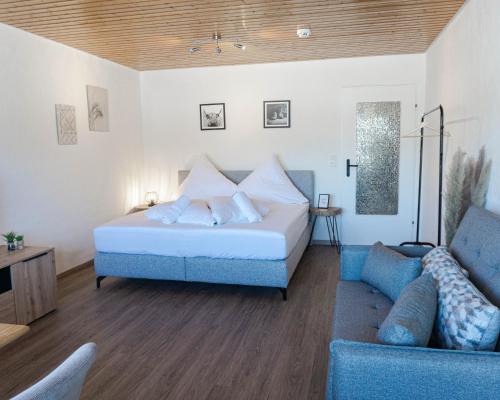 普夫龍滕的住宿－Allgäuer Panoramastube I Bergblick I Parken I WiFi，一间卧室配有一张床和一张蓝色的沙发