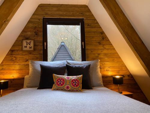 1 dormitorio con cama y ventana en Wald-Chalet Vulkaneifel, en Kerschenbach