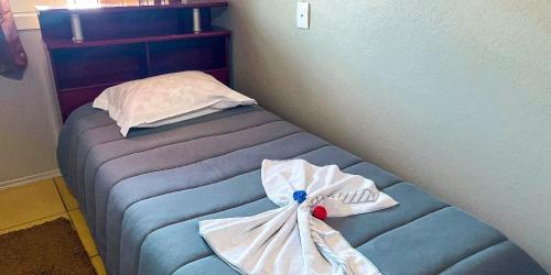 Una cama en una habitación con toallas. en Casa dos Pinheiros I, en Gramado