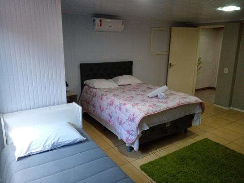 1 dormitorio con cama y sofá en Casa dos Pinheiros I, en Gramado