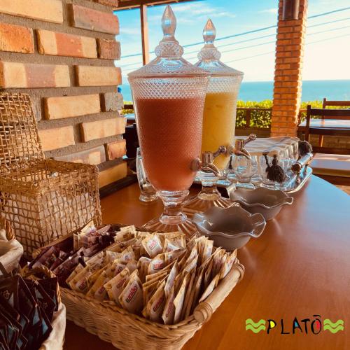 a table with two drinks and a basket of snacks at Hotel Platô in Paraipaba