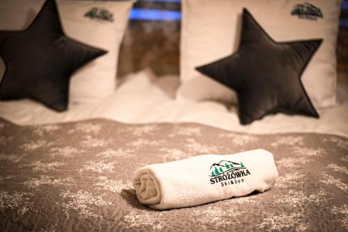 a towel sitting on top of a bed at STRÓŻÓWKA SKI&SPA Domek nad rzeką z ogrodem i jacuzzi,narty. in Stróża
