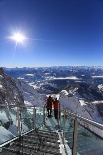 two people walking up a staircase on top of a mountain at Aparthotel Sunrise in Ramsau am Dachstein