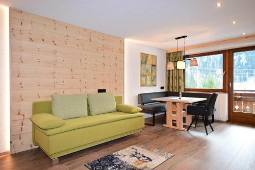 Una sala de estar con un sofá amarillo y una mesa. en Das ALPSPITZ, en Biberwier