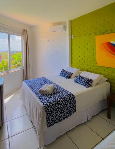 a bedroom with a bed with blue and white sheets at Hotel Platô in Paraipaba