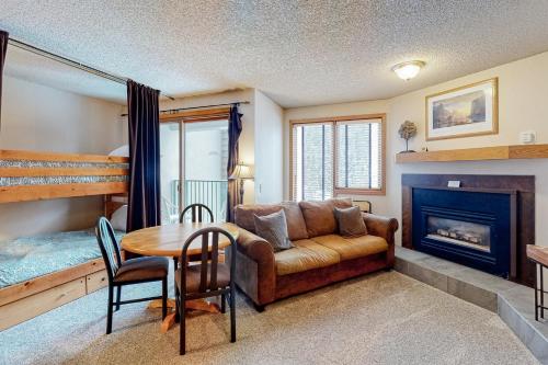uma sala de estar com um sofá, uma mesa e uma lareira em 313 Iron Horse Way #C4083 em Winter Park