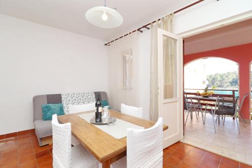 a dining room and living room with a table and chairs at Apartments Prižba Bay in Prizba