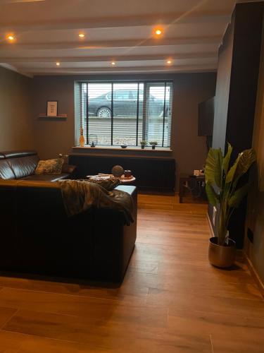 a living room with a couch and a large window at Graafjansdijk B Vakantiehuis met 3 slaapkamers net over de Belgische grens in Westdorpe