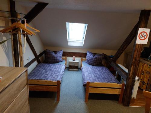 a attic room with two beds and a window at Waldquelle Plauen in Plauen