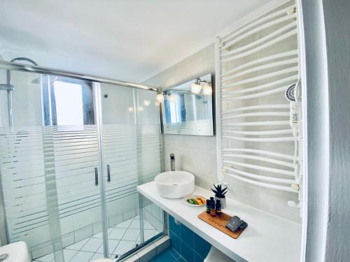 a bathroom with a glass shower and a sink at Caviro in Moudhros