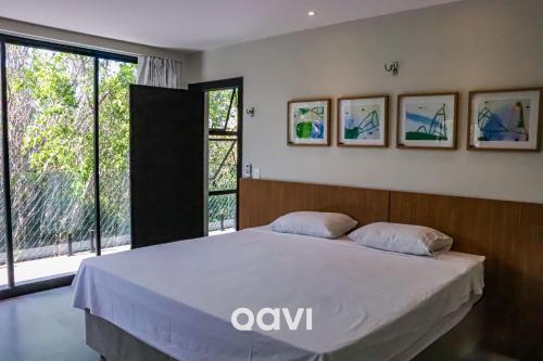 1 dormitorio con cama y ventana grande en Qavi - Casa luxuosa em condomínio fechado na praia da Pipa - #Maxlife09, en Pipa