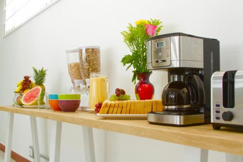 a counter with a coffee maker and fruit on it at Poblado Park Guest House in Medellín