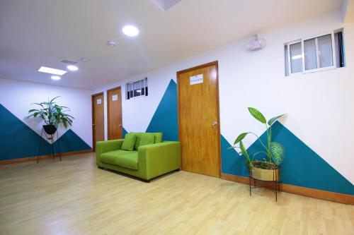 an office with a green couch in a room at Poblado Park Guest House in Medellín