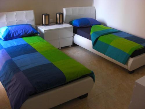 dos camas sentadas una al lado de la otra en un dormitorio en Fort Chambray Apartment, en Għajnsielem