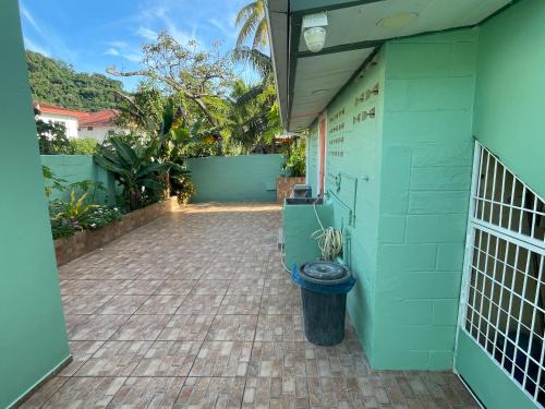 a green building with a toilet in a courtyard at Arlene's Nest Diego Martin - 3 Bedroom 1 & half bath Cozy Apt in Diego Martin