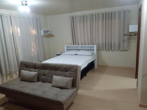 1 dormitorio pequeño con 1 cama y 1 sofá en Estúdio Palace Hotel Canela, en Canela