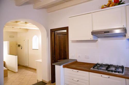 een keuken met witte kasten en een fornuis met oven bij Lovely studio steps from Basilica Santa Croce in Florence