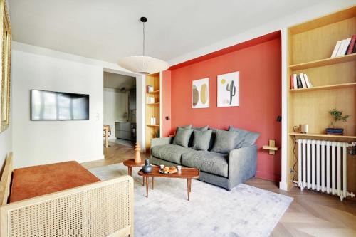 sala de estar con sofá y pared roja en Amazing apartment 8P3BDR - MontmartreSacré cœur, en París