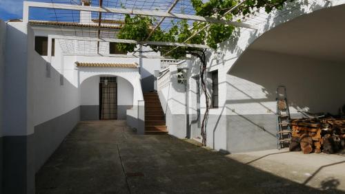 un bâtiment blanc avec une arche à côté d'un trottoir dans l'établissement Cortijo Los Liñanes, à Grenade