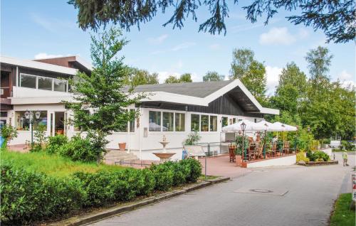 a white house with a porch and a patio at Awesome Home In Faßbergheidesee in Oberohe