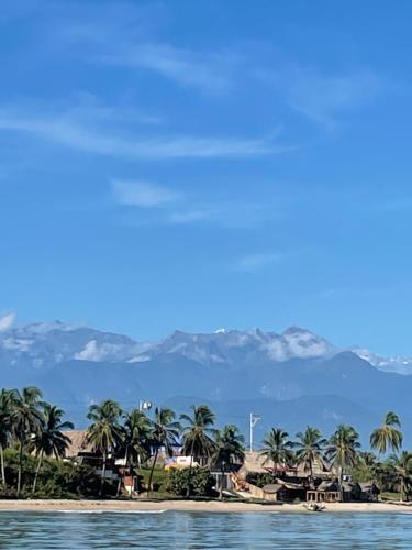 uitzicht op een strand met palmbomen en bergen bij SaBriMo in Dibulla