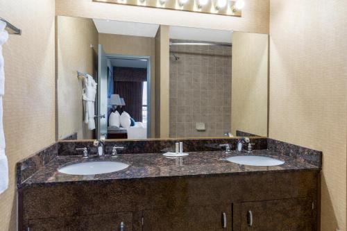 a bathroom with two sinks and a large mirror at Ramada by Wyndham Reno Hotel & Casino in Reno