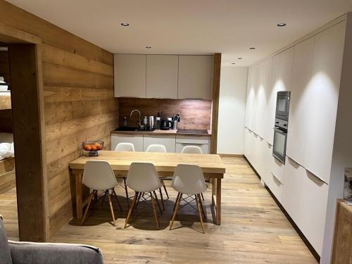 une cuisine avec une table et des chaises en bois dans l'établissement Appartement avec terrasse pour 6 personnes proche pistes à La Clusaz - FR-1-459-199, à La Clusaz