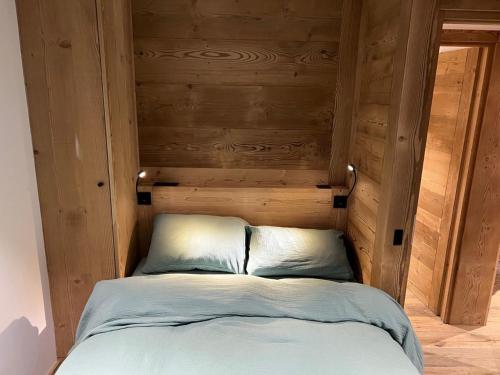 - un lit avec une tête de lit en bois dans l'établissement Appartement avec terrasse pour 6 personnes proche pistes à La Clusaz - FR-1-459-199, à La Clusaz
