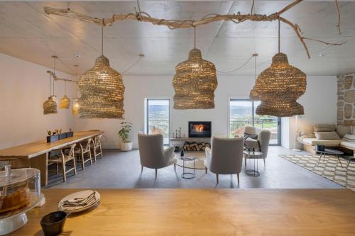 uma sala de estar com mesa, cadeiras e lustres em TheVagar Countryhouse em Belmonte