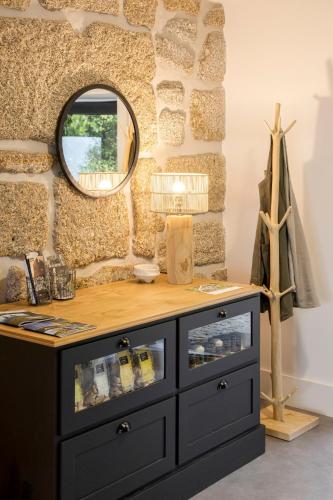 a dressing table with a mirror on a stone wall at TheVagar Countryhouse in Belmonte