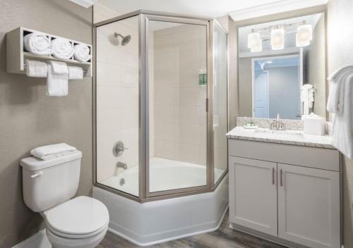 a bathroom with a shower and a toilet and a sink at Bask Hotel at Big Rock Landing in Morehead City