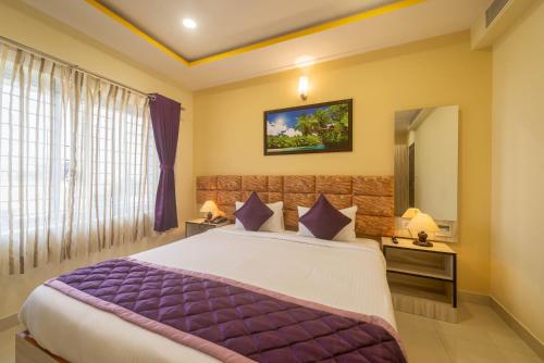 a bedroom with a large bed and a mirror at Zenith Hotels Hebbal Bangalore in Bangalore