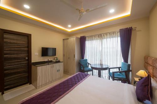 Una televisión o centro de entretenimiento en Zenith Hotels Hebbal Bangalore