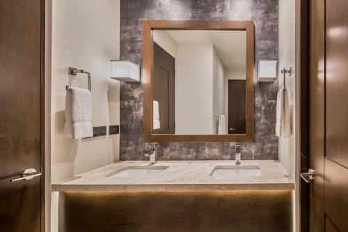 a bathroom with two sinks and a mirror at Live Aqua Private Residences Los Cabos in Cabo San Lucas