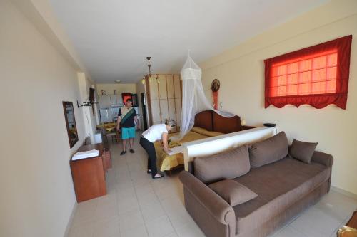 a man is assembling a couch in a living room at Koronisia Apartments in Koronisia