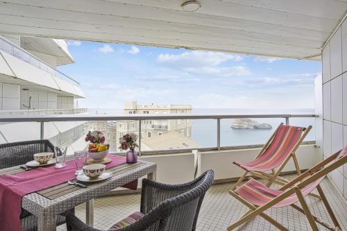 d'un balcon avec une table et des chaises et une vue sur l'eau. dans l'établissement Lovely studio with wonderful view on the sea - Welkeys, à Biarritz