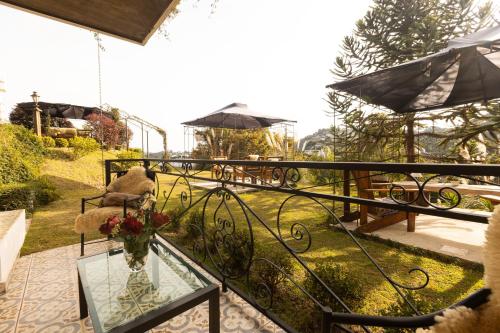 a balcony with a glass table with a vase of flowers at Casablanca Hotel Boutique in Campos do Jordão