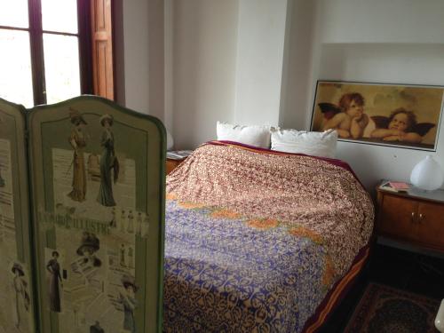 ミラノにあるLovelyloft Navigli - Gelsominoのベッドルーム1室(ベッド1台付)が備わります。壁に絵が飾られています。