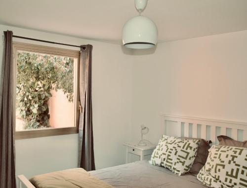 1 dormitorio con cama y ventana en Pavillon Lilly en Menton