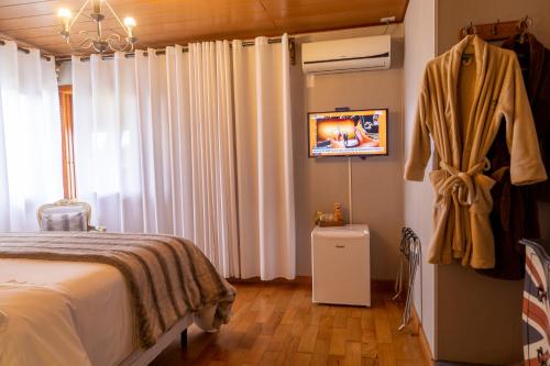 a bedroom with a bed with white drapes at Casablanca Hotel Boutique in Campos do Jordão